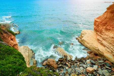 Ð¡oast of a tropical island. Sea waves break with foam on the coastal rocks. Salt water is a beautiful turquoise colorの写真素材