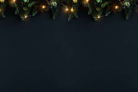 Christmas background with decorations and warm lights. Background for the new year with fir branches, cones and lights. Copy space, pattern, flat lay, cap for website, bannerの写真素材