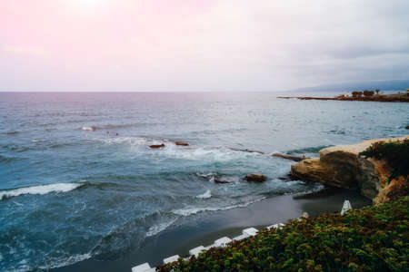 Beautiful seascape in cloudy weather. Light waves on the black sand beachの写真素材
