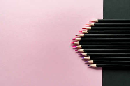 Colored pencils on a pink and black background. Pencil color gradient, top viewの写真素材