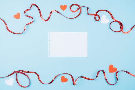 Beautiful blue background with space for text. Red ribbon and hearts. Concept of Valentines dayの写真素材