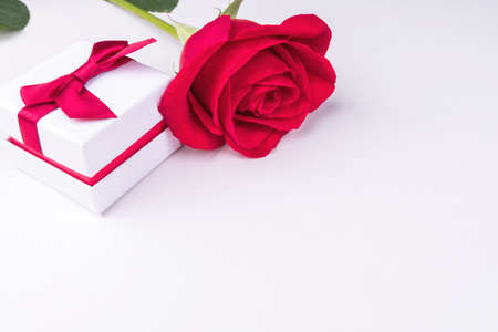 A small gift box and a red rose on a light background. The concept of Valentines day. Space for textの写真素材