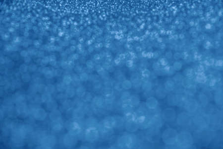 Blurred abstract background with unfocused blue sequins. Place for textの写真素材