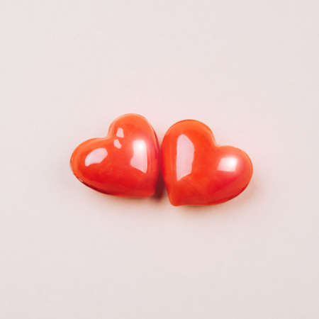 Background with two glossy red hearts. The concept of relationships and love.