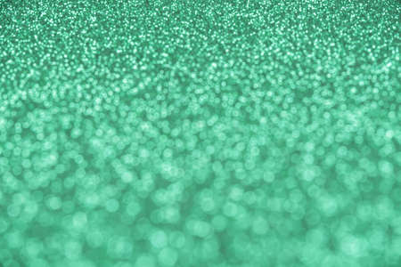 Abstract mint-colored background of blurred sequinsの写真素材
