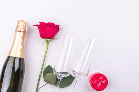 Greeting background with champagne, rose, glasses and gift box. Space for textの写真素材