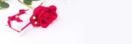 White banner with a rose and a gift in sequins and lights.の写真素材