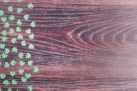 Green clover leaves on a wooden background. Background for St. Patricks Day. Space for text. Paper decorationsの写真素材