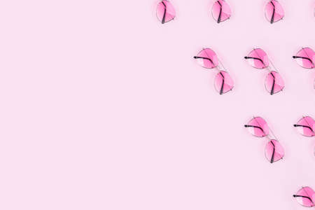 Pink stylish glasses on a pink background. Stylish summer pattern, space for textの写真素材