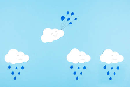 White cut-out clouds on a blue background. To be not like others, positive thinking, to see only the good. The concept of getting out of your comfort zone and turning the situation aroundの写真素材