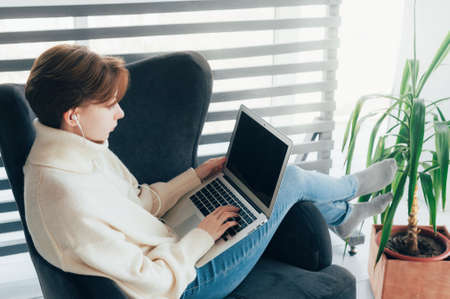 A teenage girl watching school classes on a laptop. The concept of remote learningの写真素材