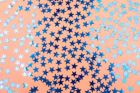Festive background of soft orange color with blue sparkling starsの写真素材