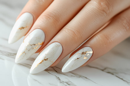 Elegant natural nail art with gold marble design on white background.の素材