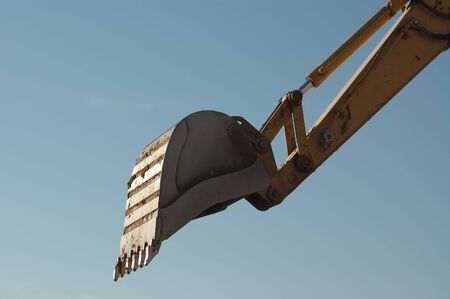 Close-up shot of trackhoe bucket at work against the blue sky morning.の写真素材