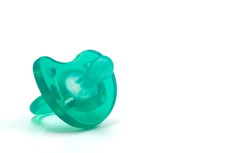 Turquoise pacifier for a newborn on a white insulated background.の写真素材