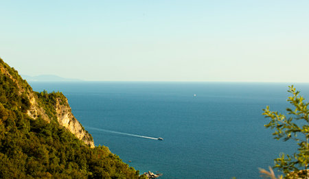 Blue sea and green mountains against blue sky. Budva. Seoce. Sailboat and yacht sailing on the...