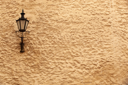 An old black lantern with glass on the yellow rough wall of a house in Tallinn. Estonia. horizontalの写真素材