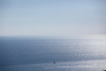 A small sailing boat sails on the sea surface of the Adriatic Sea. Balkans. View from above. Montenegro. Budva. Horizontal.の写真素材