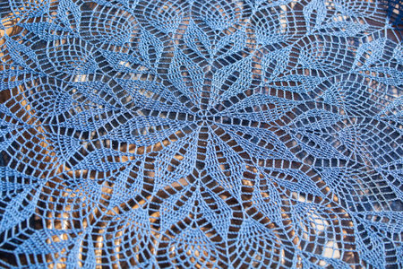 Blue handmade lace. Lace round tablecloth. Lace crochet patterns. Rustic hand crochet lace in sunshine. horizontalの写真素材