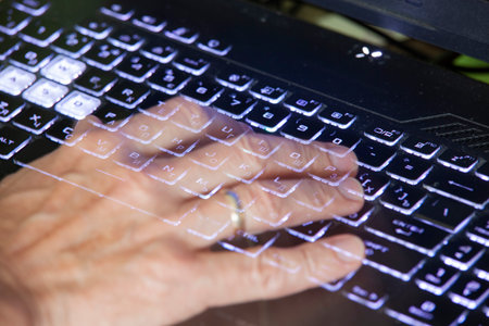 Close-up view of men's hands typing on a laptop. Relevance. Working from home, writer creating an...