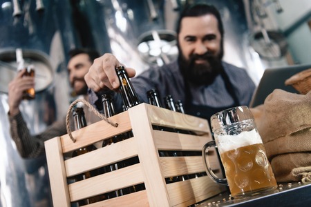 Brewers are testing beer. Beer mug on background of brewers. Brewing. Brewery. Beer crafting. Adult...