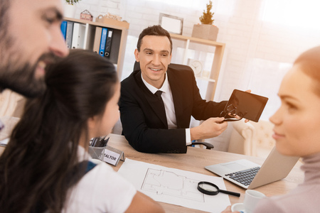 Representative realtor helps young family sell house. Concept of real estate sales. Concept of house...