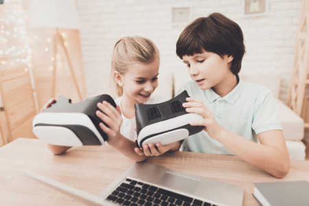 Children at table at home. Brother and sister are using virtual reality headsets.の写真素材