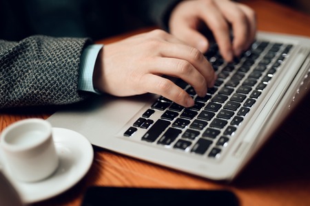 Close up. Meeting with chinese businessmen in suits in restaurant. Man is using his laptop.の写真素材