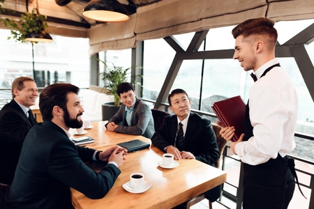 Meeting with chinese businessmen in suits in restaurant. Men are making their order.の写真素材