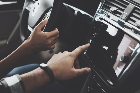 Close up dashboard of new blue car. African american family at car dealership. Mother and father are trying it out.の写真素材