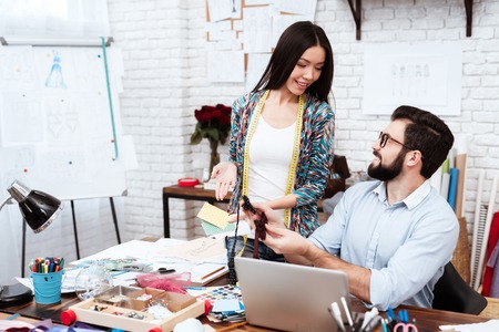 Two male and female fashion designers looking at bow ties.の写真素材