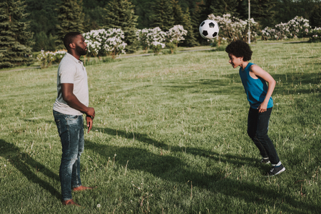 Father and son playing in the park with ball. Parent and child relationship concept.の写真素材