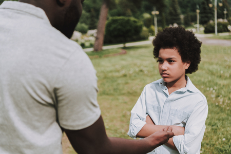Sad son with father in park. Family quarrel concept.の写真素材