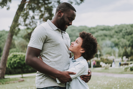 Father hugs his son in the park. They are happy.の写真素材