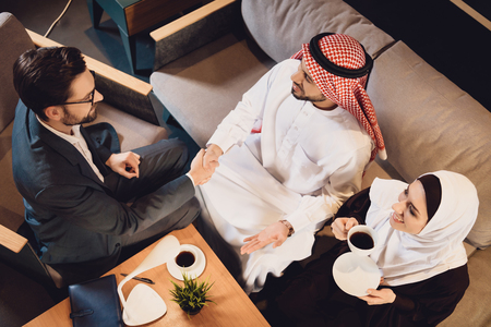 Top view. Arab man shakes hands with psychotherapist. Reception at psychologist. Visiting psychotherapist conceptの写真素材