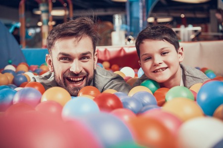 Enjoying dad and son in pool with balls. Family rest, leisure. Spending holiday together with family. Entertainment center, mall, amusement park.の写真素材
