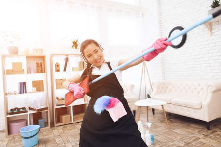Asian woman holds a mop and have fun.