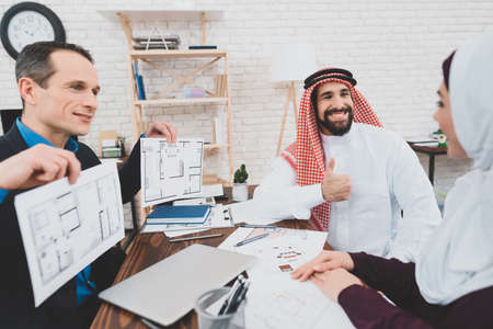 Male realtor holds apartment plans in his hands.