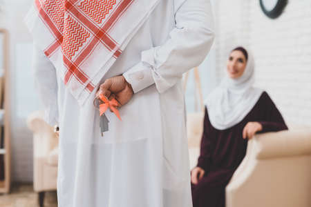 A woman sits while a man has prepared a present.