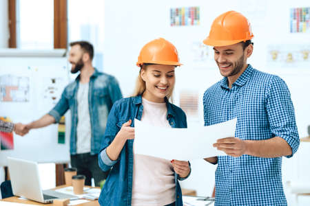 A guy and a girl are looking at a sheet of paper.