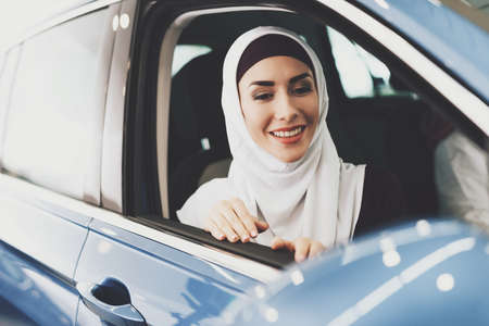 Arab woman sits in new car and looks out of windowの写真素材