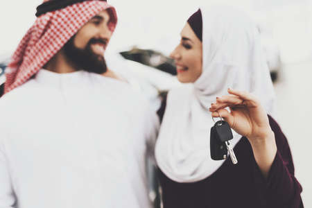 Woman in a hijab holds keys and looks at her Arab.の写真素材