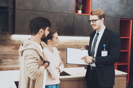 A man in a suit points to a sheet and smiles.の写真素材