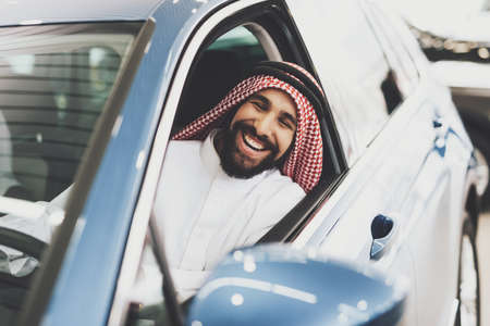 Arab man is testing a car at a car dealership.の写真素材
