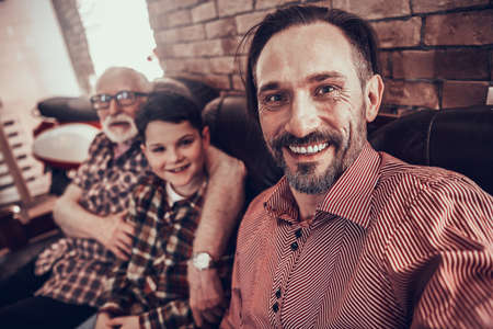 A man smiles while taking a selfie in barbershop.の写真素材