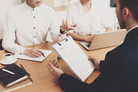 Managers sit at the table and discuss hiring man.の写真素材