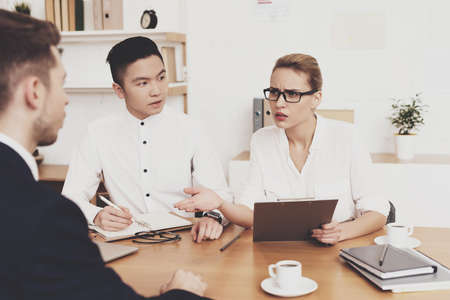 Woman with tablet talking to man at the table.の写真素材