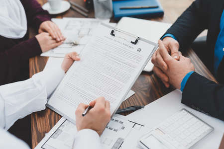 A man fills out contract while sitting in office.
