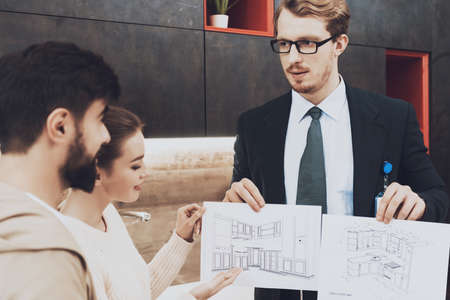 Salesperson showing kitchen plans to buyers.