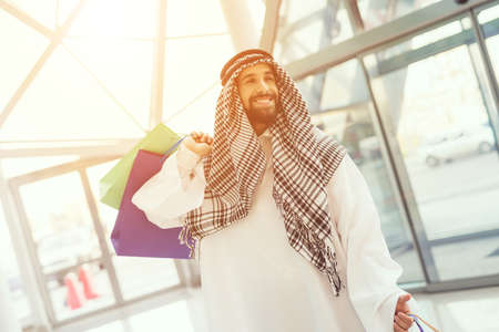 Young Arabian Man with Packages Standing in Mall.の写真素材